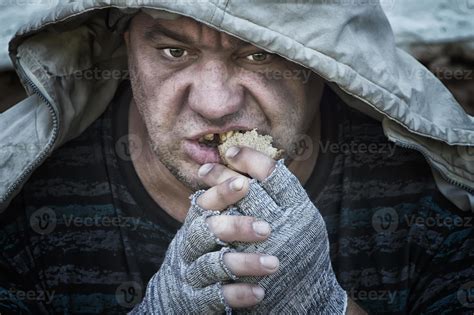 A Homeless Toothless Hungry Man Greedily Eats A Piece Of Bread