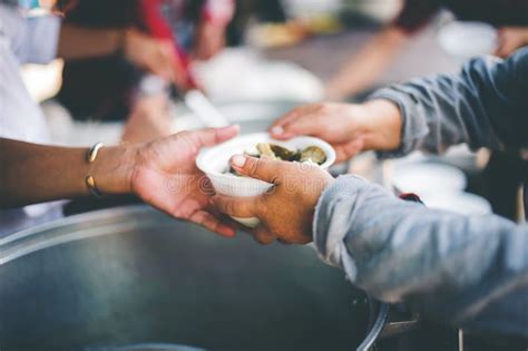 Homeless And Needy People Receive Help Receive Food From Volunteers