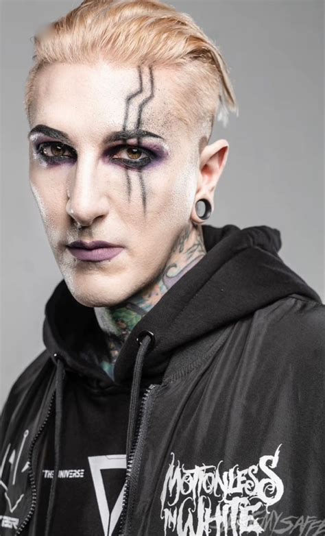 A Man With White Makeup And Black Eyeliners On His Face Is Posing For