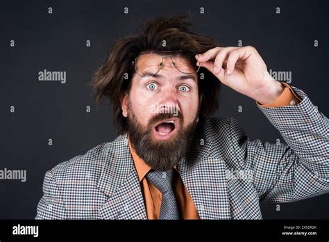 Portrait Of Confused Businessman With Beard Taking Off Glasses