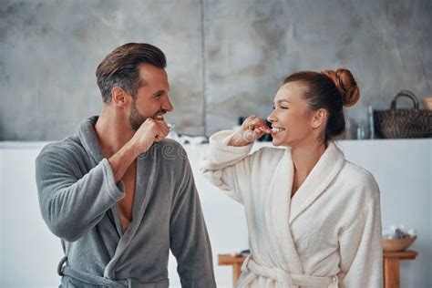 Feliz Pareja Joven En Batas Limpiando Dientes Mientras Hace Rutina