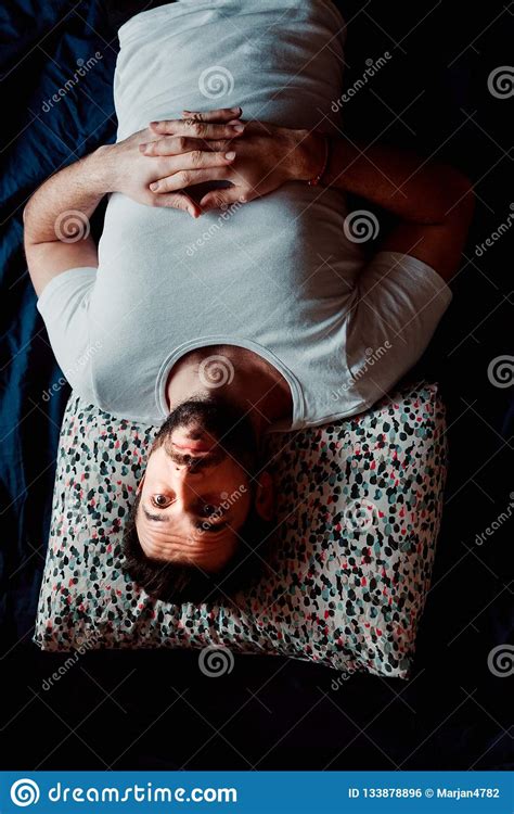 Hombre Joven Que Miente En El Pensamiento De La Cama Foto De Archivo