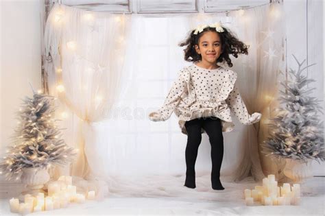 Year Old Latina Girl With Curly Hair Jumps On The Bed In Excitement Of Celebrating Christmas