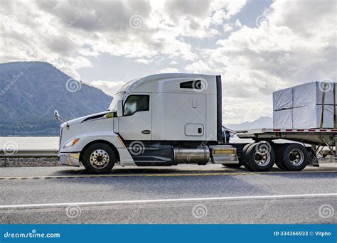 Big Rig White Semi Truck With Aerodynamic Profile Transporting Fastened