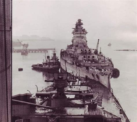 An Old Black And White Photo Of A Battleship In The Water With Other