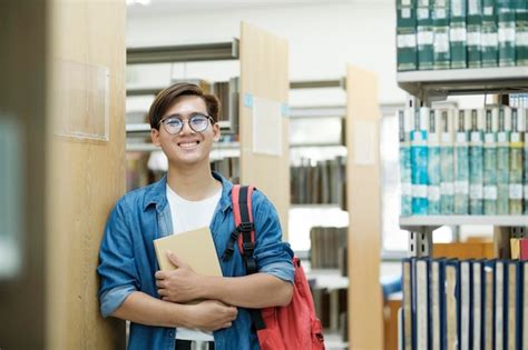 Aluno Escolhendo E Lendo Livro Na Biblioteca Foto Premium