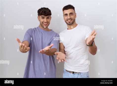 Homosexual Gay Couple Standing Over White Background Smiling Cheerful Offering Hands Giving