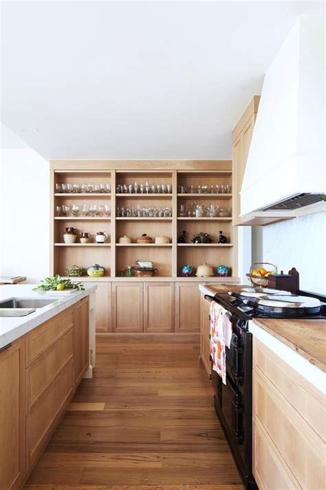 A Kitchen With Wooden Cabinets And White Counter Tops Along With