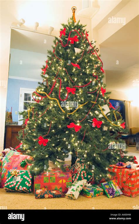 Large Christmas tree with presents around base Stock Photo - Alamy