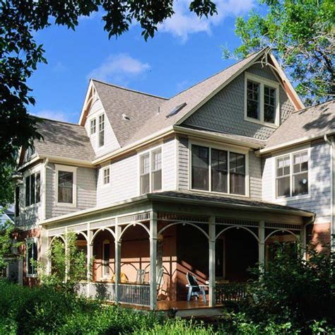 A Large White House Sitting On Top Of A Lush Green Field Next To Tall Trees