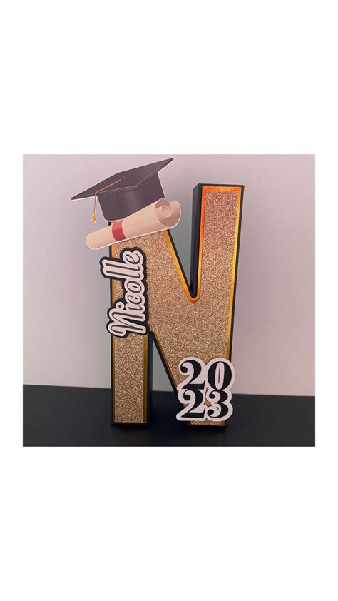 A Wooden Letter With A Graduation Cap On Top