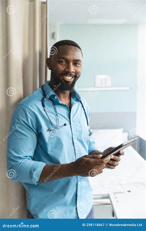 Portrait Of Happy African American Male Doctor Using Tablet In Hospital