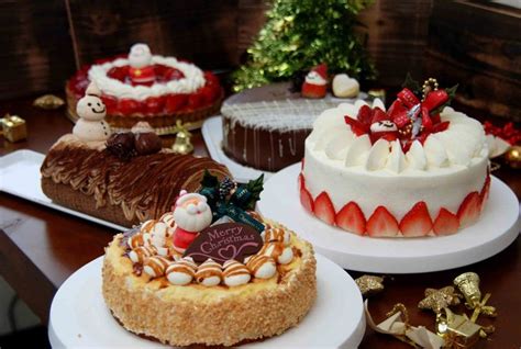 Three Cakes On Plates With Decorations Around Them And One Has A Santa