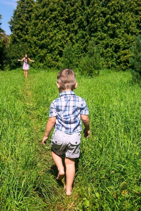 Il Ragazzo Scalzo Va Generare Sulla Pista Fra Alta Erba Fotografia