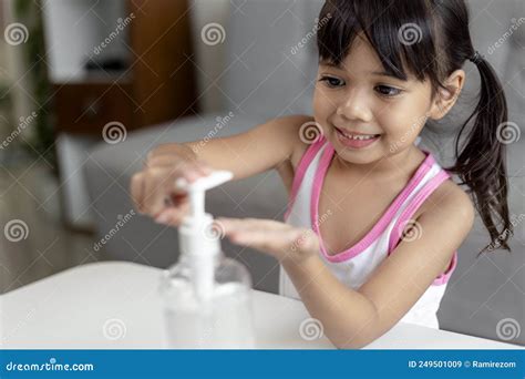 Little Asian Girl Child Put Alcohol Gel Sanitizer Pump On Hands For