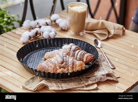 French aesthetic breakfast - powdered croissants with glass of latte outside Stock Photo - Alamy