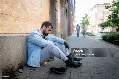 young hungry unemployed sick depressed homeless homeless man sitting