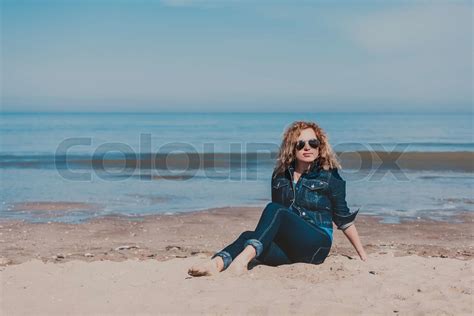 Young woman walking alone on the beach | Stock image | Colourbox