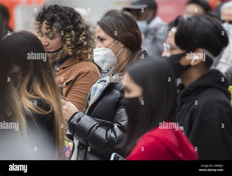 La gente usa máscaras faciales mientras ve a un artista callejero en