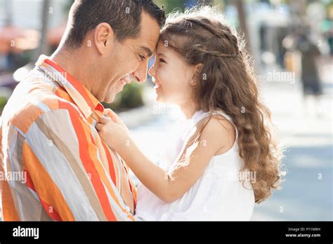 Close Up Of Hispanic Father And Daughter Touching Foreheads Stock Photo