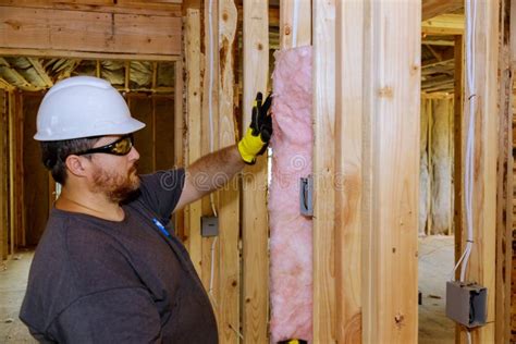 Construction Worker Installing Thermal Insulation Layer Under The Wall