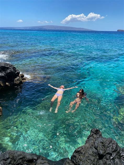 Two People Are Swimming In The Clear Blue Water