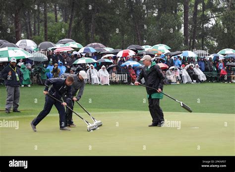 Grounds Crew Squeegee The Green During The Day Of The Masters