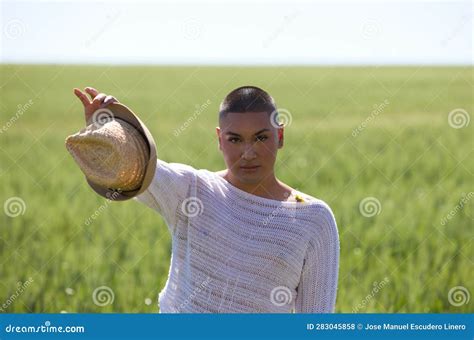 Retrato De Una Joven Latina No Binaria Sosteniendo Un Sombrero De Paja En Su Mano Y Parado En El