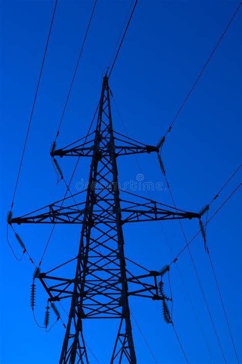 High Voltage Electric Tower Silhouette On Bright Blue Background Stock