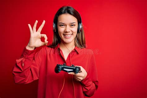 Jovencita Guapa Jugadora De Brunette Que Juega Videojuego Usando Joystick Y Auriculares Haciendo