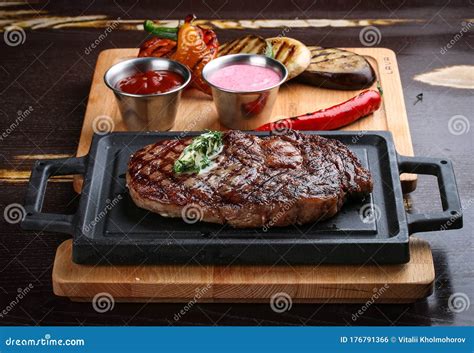 Rib Eye Steak On Wooden Tray With Grilled Vegetables Stock Photo