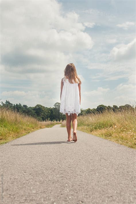 "Little Girl Barefoot In A White Dress Walking On A Long Road" by Stocksy Contributor "Cindy ...