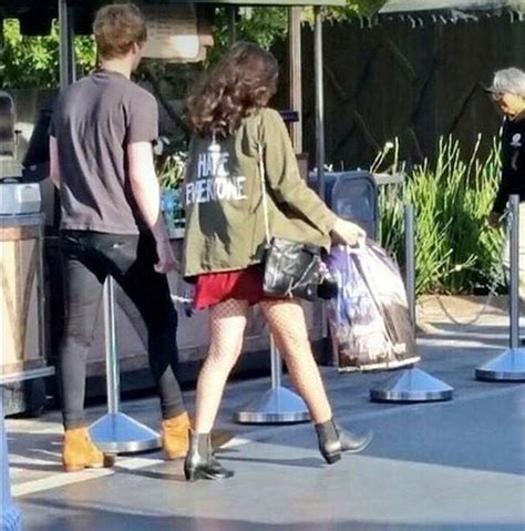 Two People Are Walking Down The Street With Bags In Their Hands And One