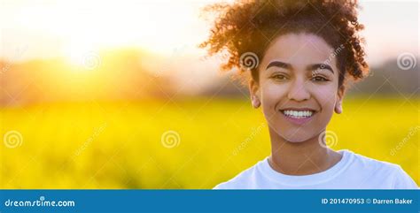 Mixed Race African American Girl In A Field Of Yellow Flowers At Sunset