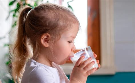 El Primer Plano De Una Ni A Linda Bebiendo Leche Desayunando Con Un