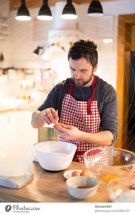 Smiling Man Preparing Meal Looking At Wife A Royalty Free Stock Photo