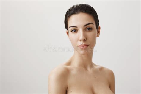 Waist Up Portrait Of Beautiful Woman With Natural Beauty Standing Naked Against Gray Background