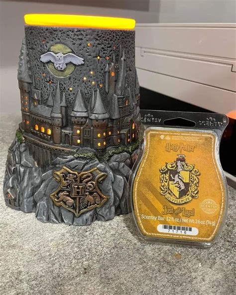 A Hogwarts House Candle Holder Next To A Harry Potter Money Box On A