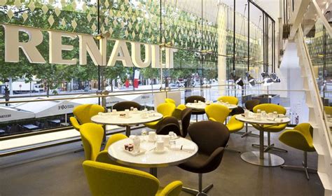 The Interior Of A Restaurant With Yellow Chairs And Tables In Front Of