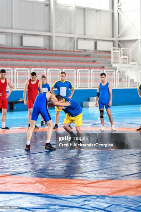 Wrestling Coach Demonstrating Techniques To Students During Practice