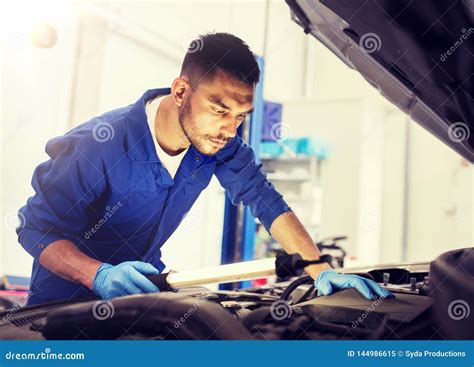 Homem Do Mec Nico A L Mpada Que Repara O Carro Na Oficina Imagem De