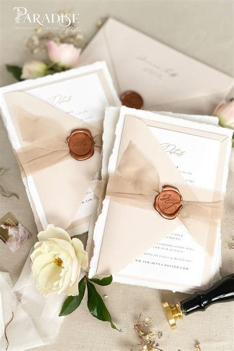 The Wedding Stationery Is Laid Out On Top Of Each Other With Flowers