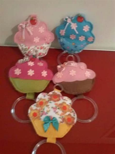 Four Cupcakes Are On Display In Front Of A Red Table With White Walls