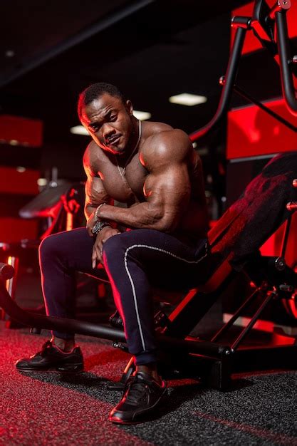 Premium Photo Strong Bodybuilder With Naked Torso Rests After Heavy Workout In Gym African