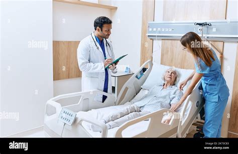 Bedside Consultation At Modern Hospital Senior Woman Lying On Hospital