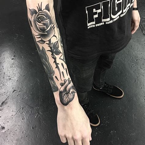 A Man With A Rose Tattoo On His Arm