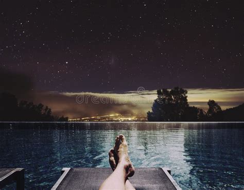 Relaxing in Holidays, a Man Feet on Bed at Swimming Pool at Night with ...