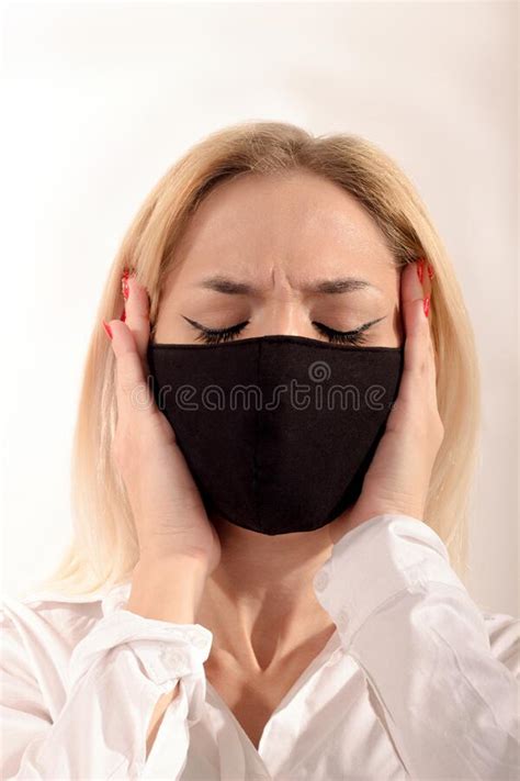 A Young Girl In Stress In A Black Mask Holds Her Hands On Her Face