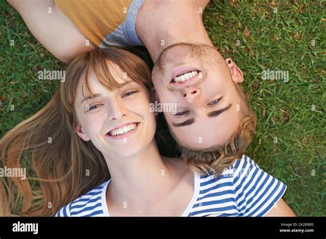 Relaxing In The Park Portrait Of A Happy Young Couple Lying In The