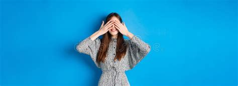 Happy Smiling Woman In Dress Cover Eyes With Hands Waiting For